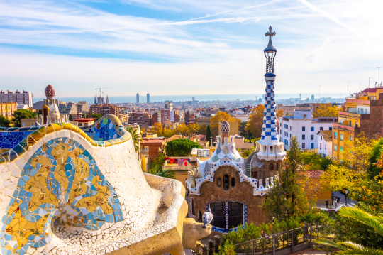 Blick über Barcelona mit seiner bunten Architektur, am Horizont das Meer