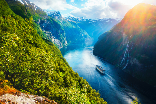 Schiff schlängelt sich durch einen norwegischen Fjord